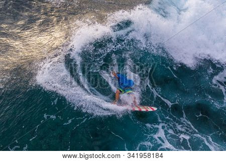 Surfer falls from his surfboard into the wave after unsuccessfull maneuver, shot on the island of Oahu, Makaha surf spot, Hawaii