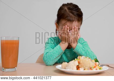 Cute Little Girl Crying And Refusing To Eat Vegetable Salad At Table On Grey Background