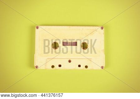 Toned Photo Of Old Audio Cassettes On The Yellow Paper Background Closeu