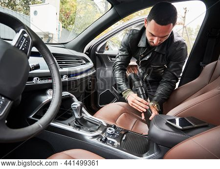 View From Inside A Car On Young Man Washing Car On Carwash Station Outdoor. Handsome Driver Cleaning