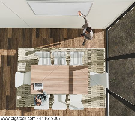 Top View Of Young Businessman Presenting To Colleague In Meeting Room.  Male Business Coach Training