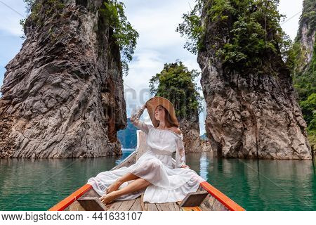 Young Female Tourist In Dress And Hat At Longtail Boat Near Famous Three Rocks With Limestone Cliffs