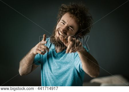 Cheerful Guy In A Blue T-shirt With Happy Eyes And A Wide Smile Points His Fingers To The Camera. Cl