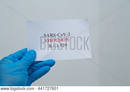 A Hand Holding Sars-ccv-2 Omicron Variant B.1.1.529 Text Written On A Piece Of Paper.