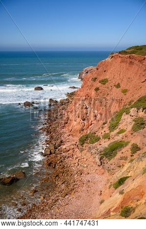 A View From Over The Cliff To The Atlantic Ocean And The Waves Crashing Against The Rocks In The Por
