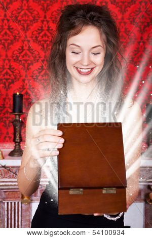 Smiling Girl In Evening Dress Opening A Gift Wooden Box In Vintage Interior