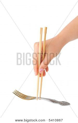 Main avec baguettes et fourchette