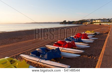 Pedalos Goodrington beach near Paignton Devon England with colourful beach huts