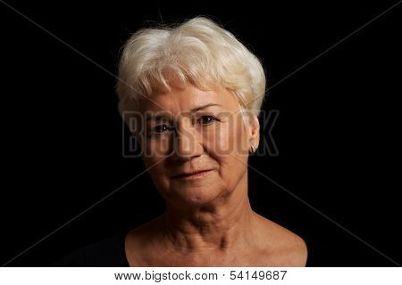 Portrait of an old attractive lady over black backrgound.