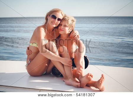 young beautiful mather with son by the boat 