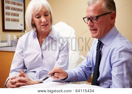 Cosmetic Surgeon Discussing Proceedure With Client In Office