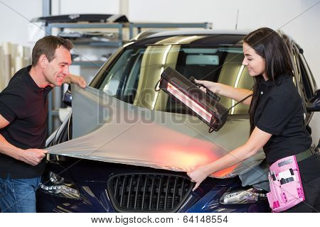 Car Wrappers Using Red Light Lamp To Flatten Vinyl Film
