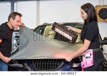 Car Wrappers Using Red Light Lamp To Flatten Vinyl Film