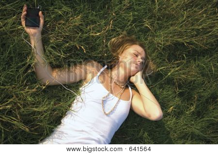 Pěkně dospívající dívka poslouchá přenosný hudební přehrávač