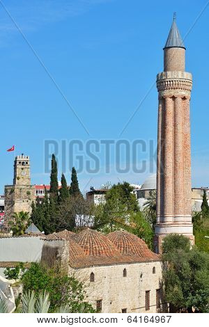 ANTALYA, TURKEY - MARCH 26, 2014: Yivli minaret mosque and clock tower in Antalya. Built in XIV century, this 38 metres tall minaret is now the symbol of the city