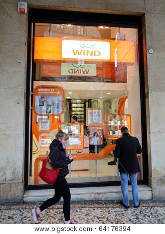 BOLOGNA, ITALY - APRIL 19, 2014: Pedestrians walk past a Wind Telecomunicazioni SpA mobile telephone store in Bologna, Italy, on Saturday, April 19, 2014. 