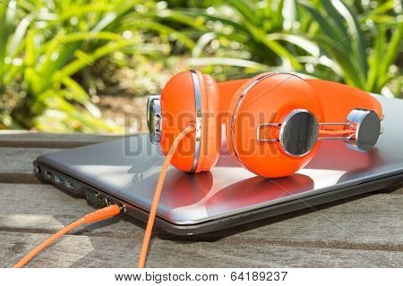 Bright Coloured Orange Headphones And Mobile Computer