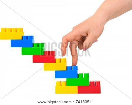 Hand and toy stairs isolated on white background