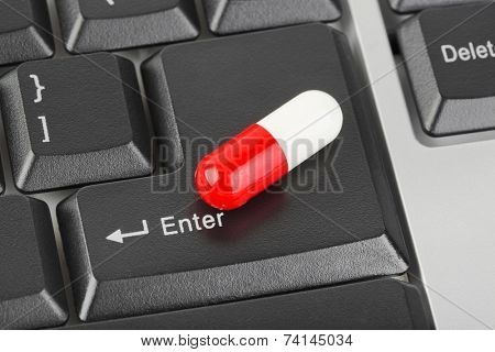 Pill on computer keyboard - concept technology background