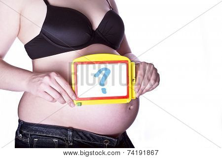 pregnant woman clothed in black bra and jeans holding a toy slate with a questionmark in front of her belly