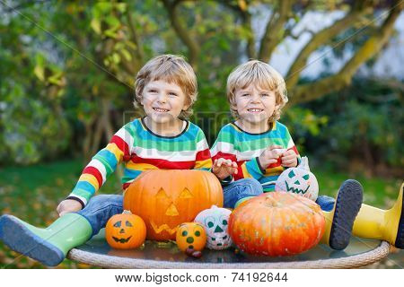 Two Little Friends Boys Making Jack-o-lantern For Halloween In Autumn Garden