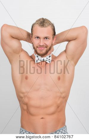 topless man wearing a skull, neckbow and smiling