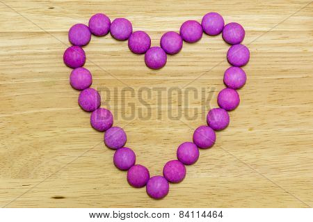 Sugar Coated Candy Heart on Wooden Background