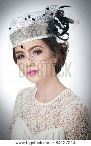 Hairstyle and make up - beautiful young girl art portrait. Cute brunette with white cap and veil