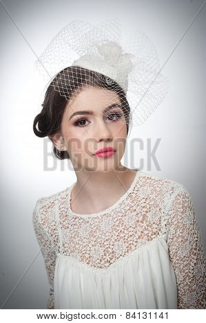 Hairstyle and make up - beautiful young girl art portrait. Cute brunette with white cap and veil