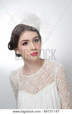 Hairstyle and make up - beautiful young girl art portrait. Cute brunette with white cap and veil