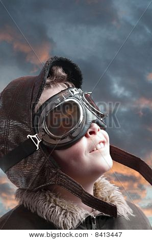 Boy Playing With Pilot´s Hat And Cloudy Background