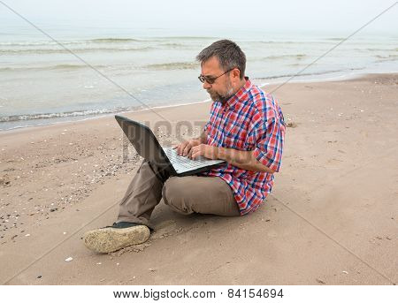 Old Man Sitting With A Laptop