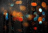 Drops Of Rain On Glass With Defocused Lights. Abstract Background
