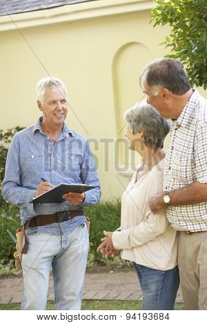 Repairman Giving Senior Couple Estimate For Roof Repair