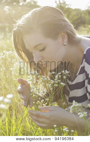 young woman smelling flowers in nature