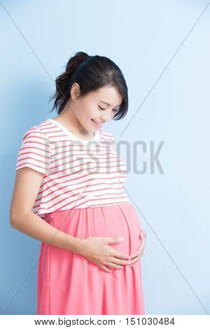 pregnant woman is smile isolated on bluebackground asian