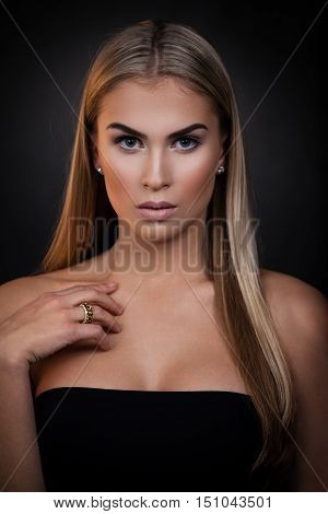 Sexy blond woman posing on dark background