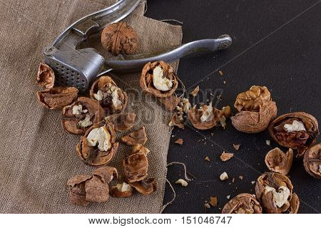 walnuts and a nutcracker on a table covered with burlap