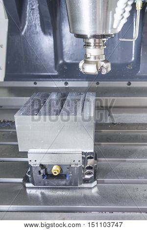 The face milling tool with the raw material work piece on the CNC milling machine.The spindle with holder and tooling for face milling on CNC milling machine