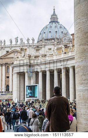 Rome 23 March 2014: A group of believers in St. Peter's Square careful listening to the Angelus of the Pope Francis. Pope Francis on the big screen. March 23 2014 Vatican City Italy