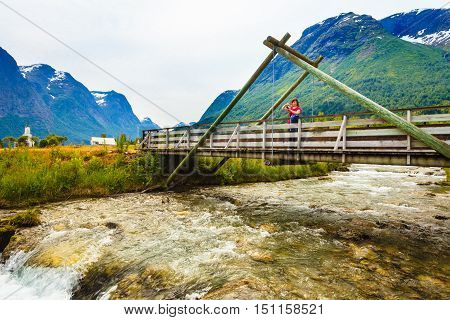 Tourist Relaxing On Bridge In Village Oppstryn Norway