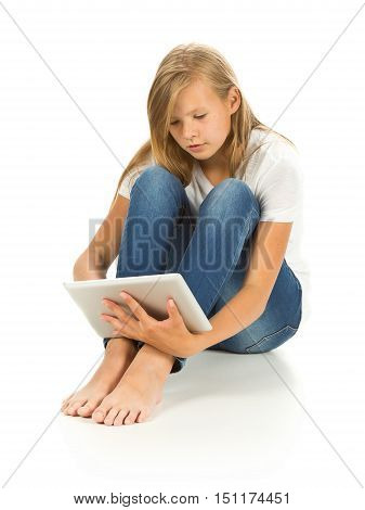 Young girl sitting on the floor using tablet pc over white background