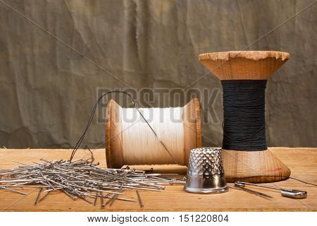 two spools of thread with thimble on the dark background