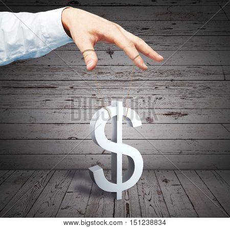 Male hand controlling dollar sign as puppet on wooden background. Price manipulation concept