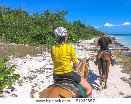 Bayahibe, Dominican Republic - May 26, 2006: tourists on horseback along the coast of the Parque Nacional del Este, Dominican Republic. Horse riding is an activity very practiced in Bayahibe.