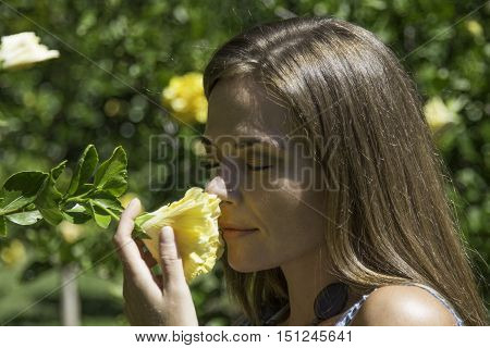 Female smelling the scent of a blossoming flower
