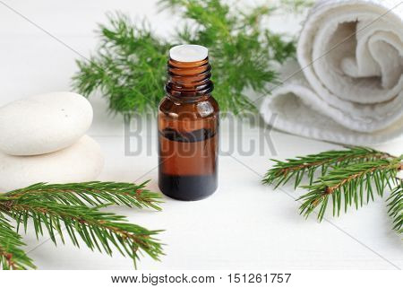 Green eco cosmetics spa treatment. Essential oil, aromatic pine twigs, white towels. Relaxing beauty care.