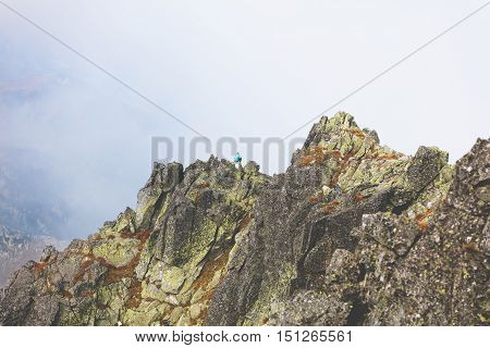 lonely tourist enjoys stunning panorama of foggy mountain from the peak. High Tatras, Zakopane, Poland