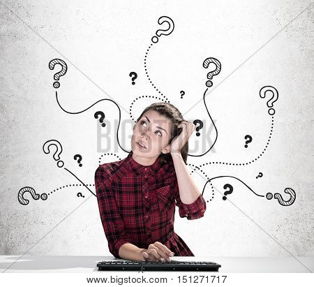 Portrait of girl with keyboard surrounded by question mark on cords drawn on concrete wall. Concept of school project writing