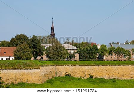 NARVA, ESTONIA - AUGUST 21, 2016: One of the bastions of Hermann Cstle. On the background is spire of Old Town Hall